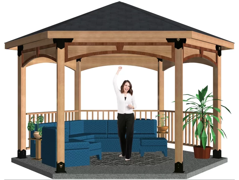 A woman stands smiling with one arm raised inside a Surface Mounted, DIY 6x6 Hexagon Gazebo featuring a dark roof, blue seating, a small table, potted plants, and a patterned rug on the floor.