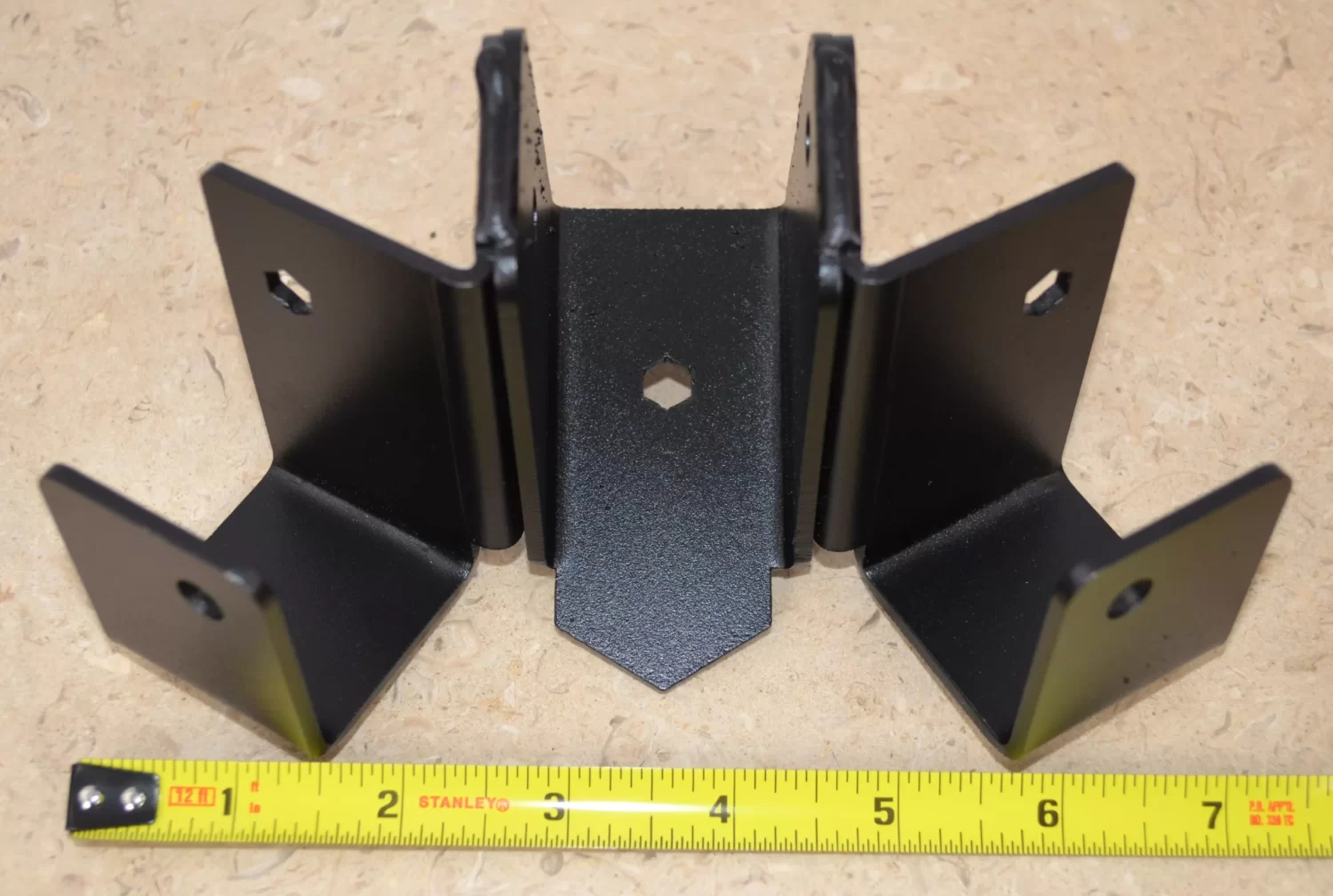 DSC_0105 This black metal bracket features a unique design for stable attachment, commonly used in construction projects for holding equipment securely in place