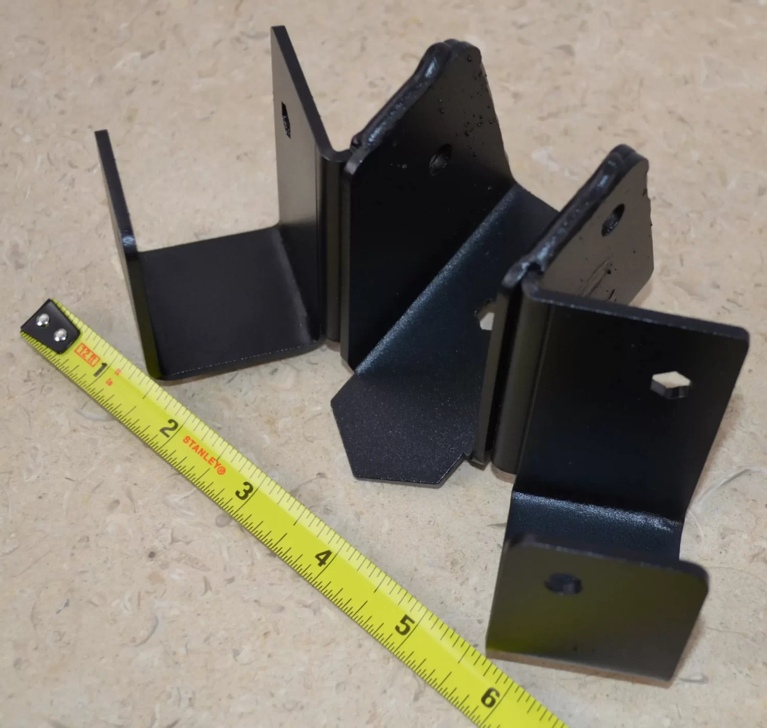 DSC_0109 This black metal bracket features a unique design for stable attachment, commonly used in construction projects for holding equipment securely in place