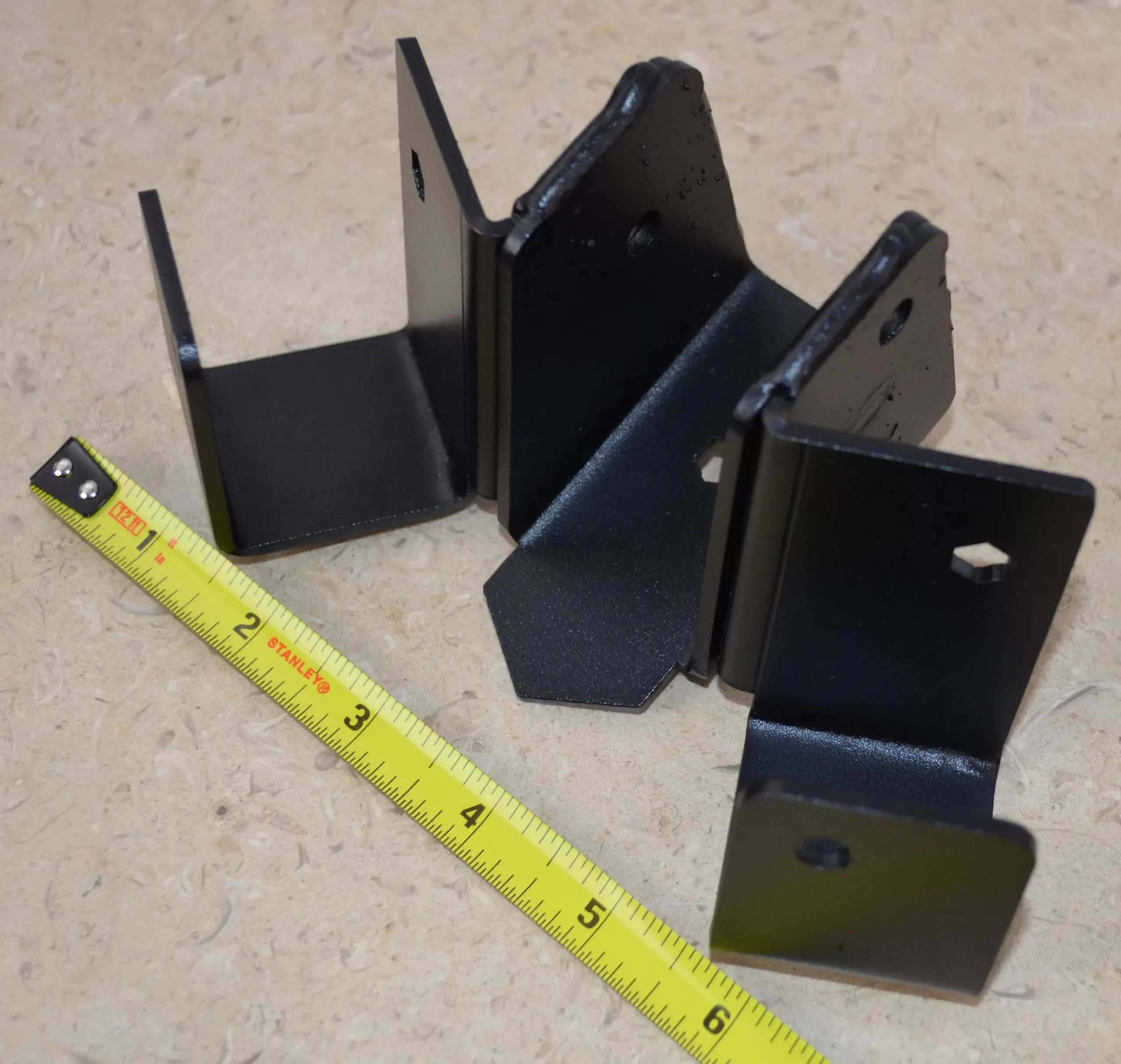 This black metal bracket features a unique design for stable attachment, commonly used in construction projects for holding equipment securely in place