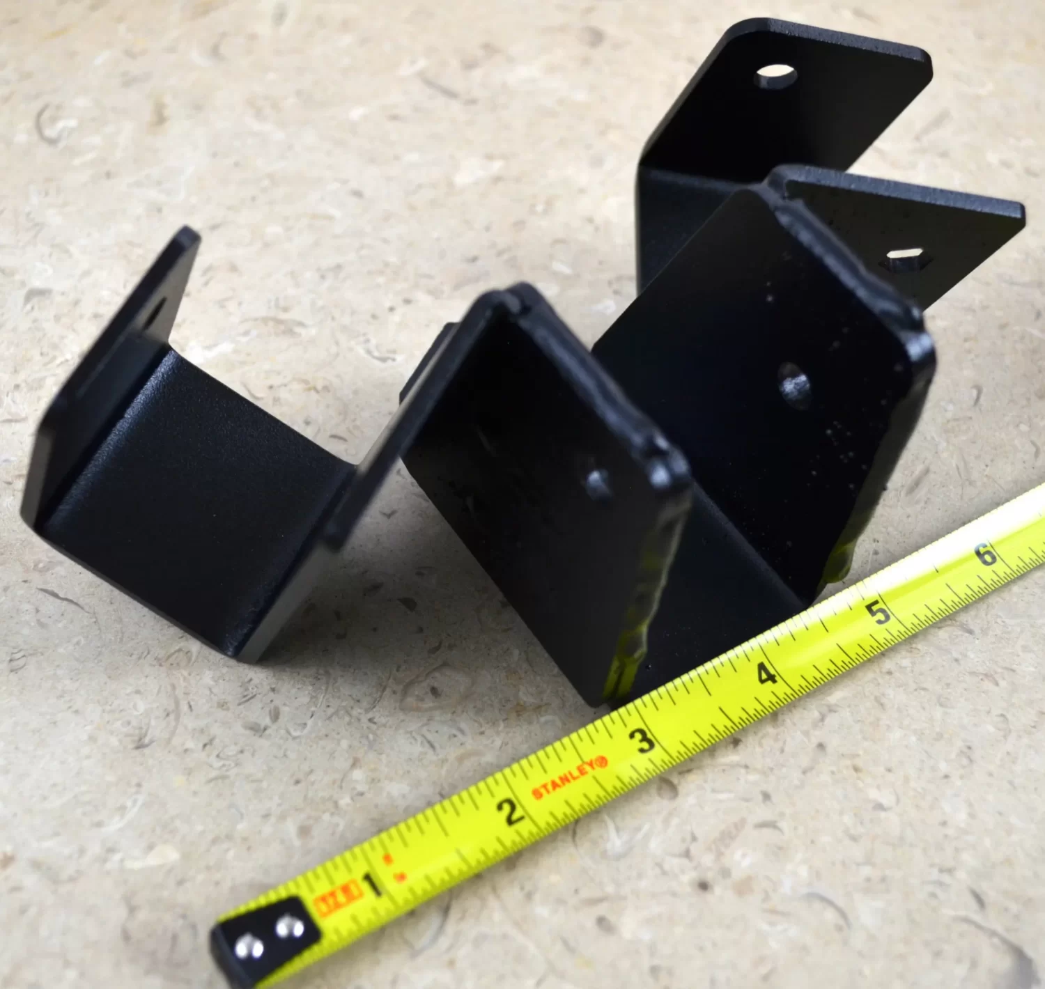 DSC_0116 This black metal bracket features a unique design for stable attachment, commonly used in construction projects for holding equipment securely in place