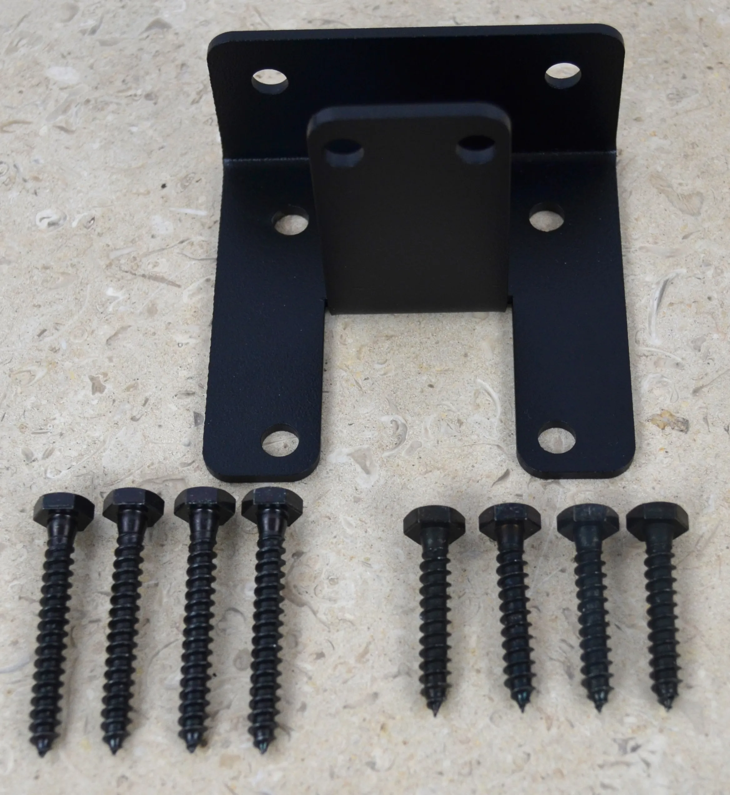 DSC_0001 The image displays an open end rafter tie bracket alongside various lag screws, used for securely connecting rafters during roof construction.