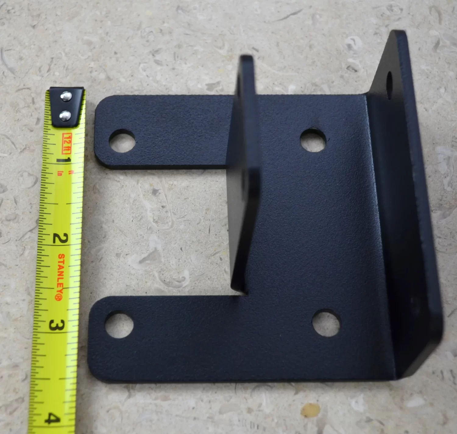 DSC_0139 This black metal open end rafter tie bracket features multiple mounting holes, providing strong support for construction and assembly tasks in various settings.