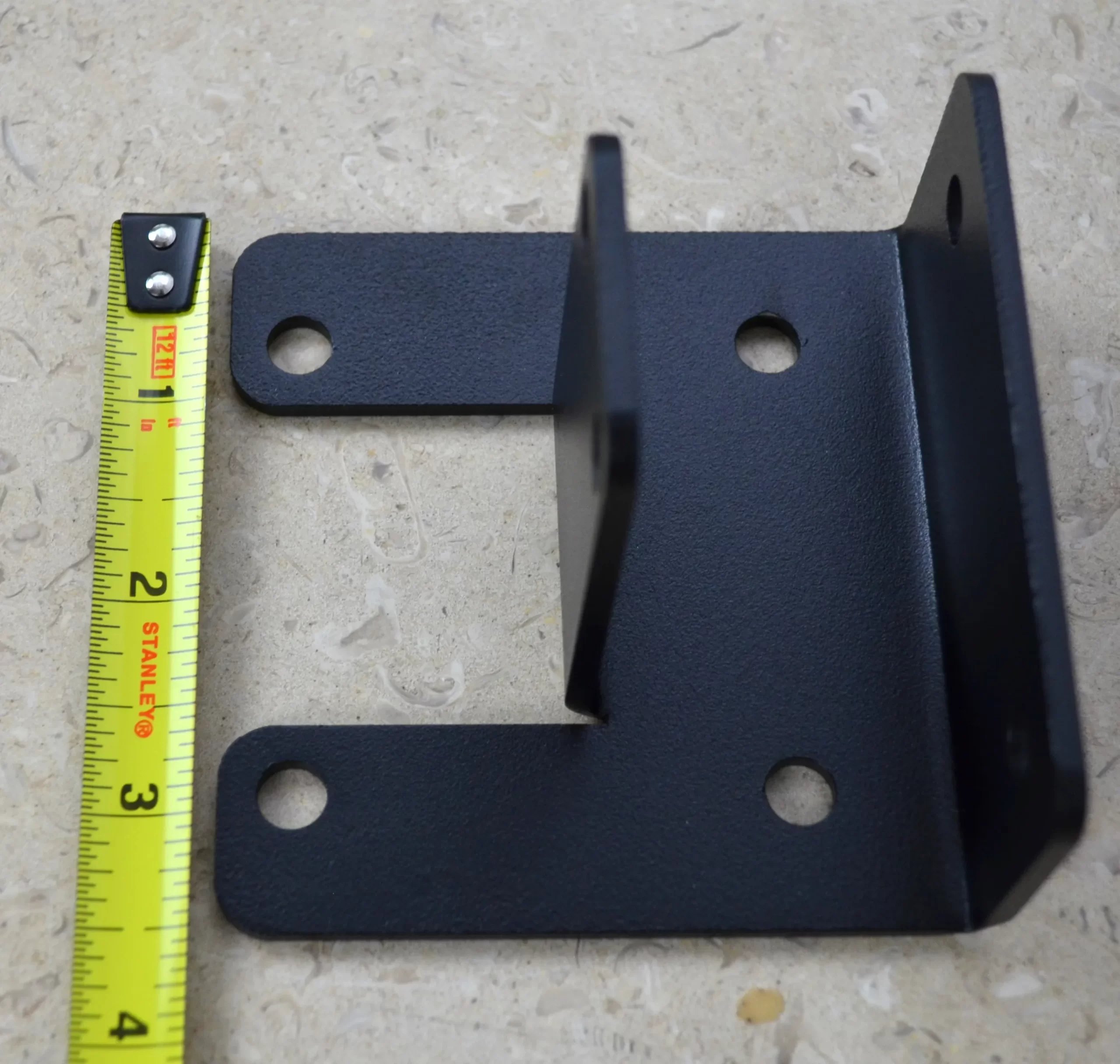 DSC_0139 This black metal open end rafter tie bracket features multiple mounting holes, providing strong support for construction and assembly tasks in various settings.