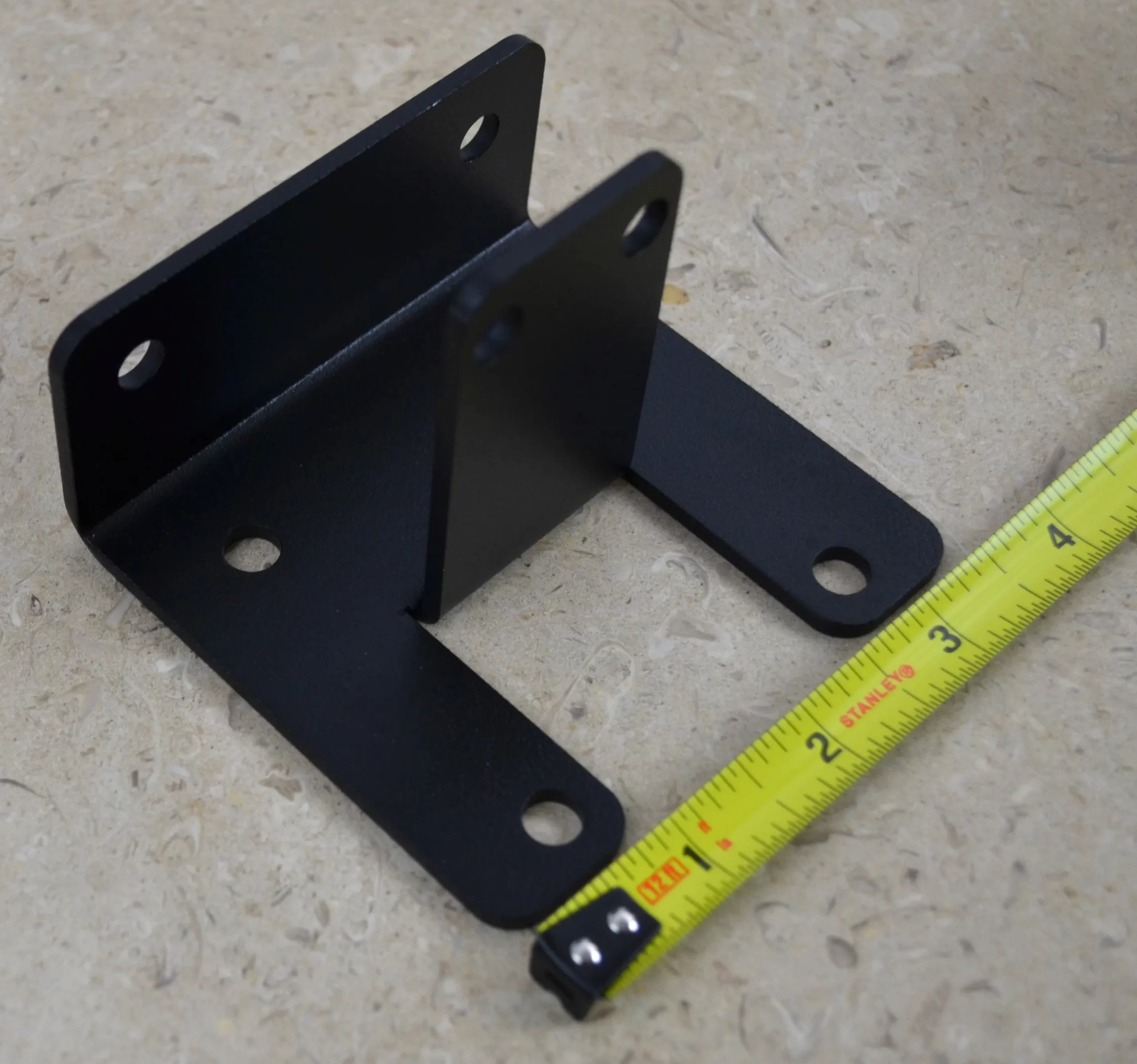 DSC_0141 This black metal open end rafter tie bracket features multiple mounting holes, providing strong support for construction and assembly tasks in various settings.