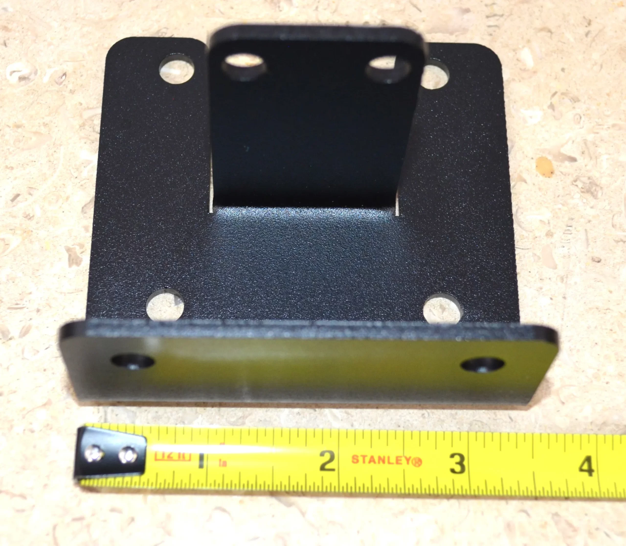 DSC_0142 This black metal open end rafter tie bracket features multiple mounting holes, providing strong support for construction and assembly tasks in various settings.