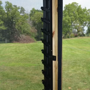 DSC_0072 A Decorative 36 DIY Louver Kit in black metal is mounted vertically on a wooden post outdoors, featuring angled slots with green grass and trees visible in the background.